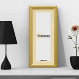 Antique Style Panoramic Gold Picture Frame With Ivory Mount Photo Frame is standing with the wall on a white wooden shelf with a black lamp and a black a flower pot place near it.
