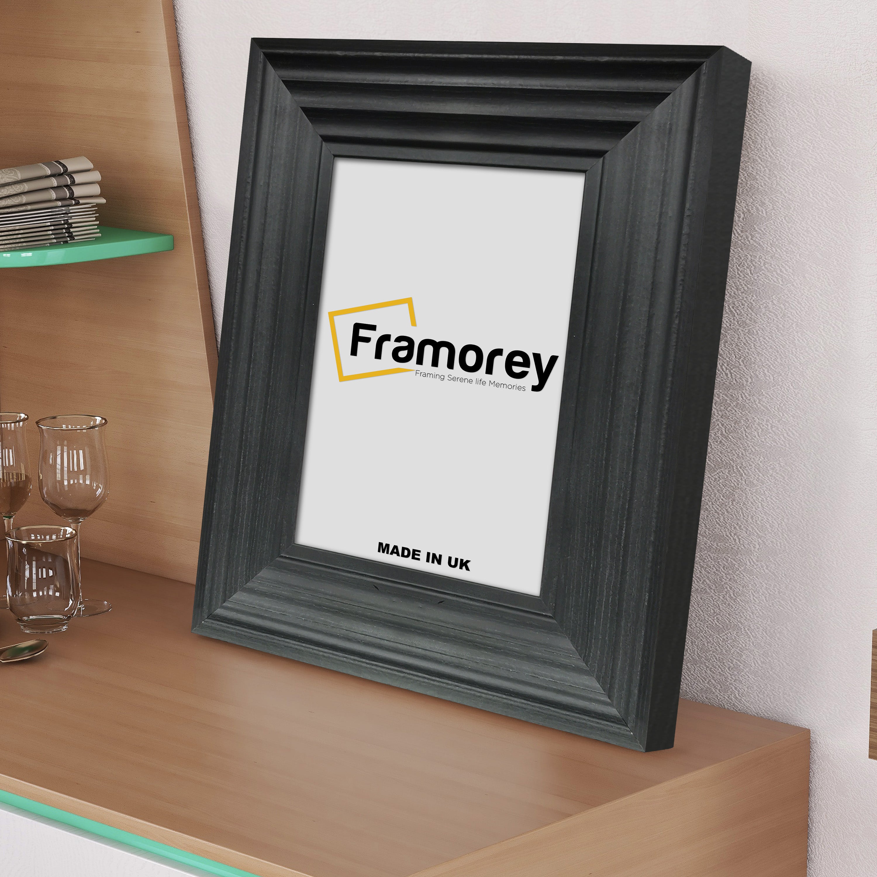 Black picture frame shown from Side view on a table standing with a wall