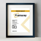Thin Matt Black Solid Wood Picture Frame With White Mount on a plain white surface standing with a wall