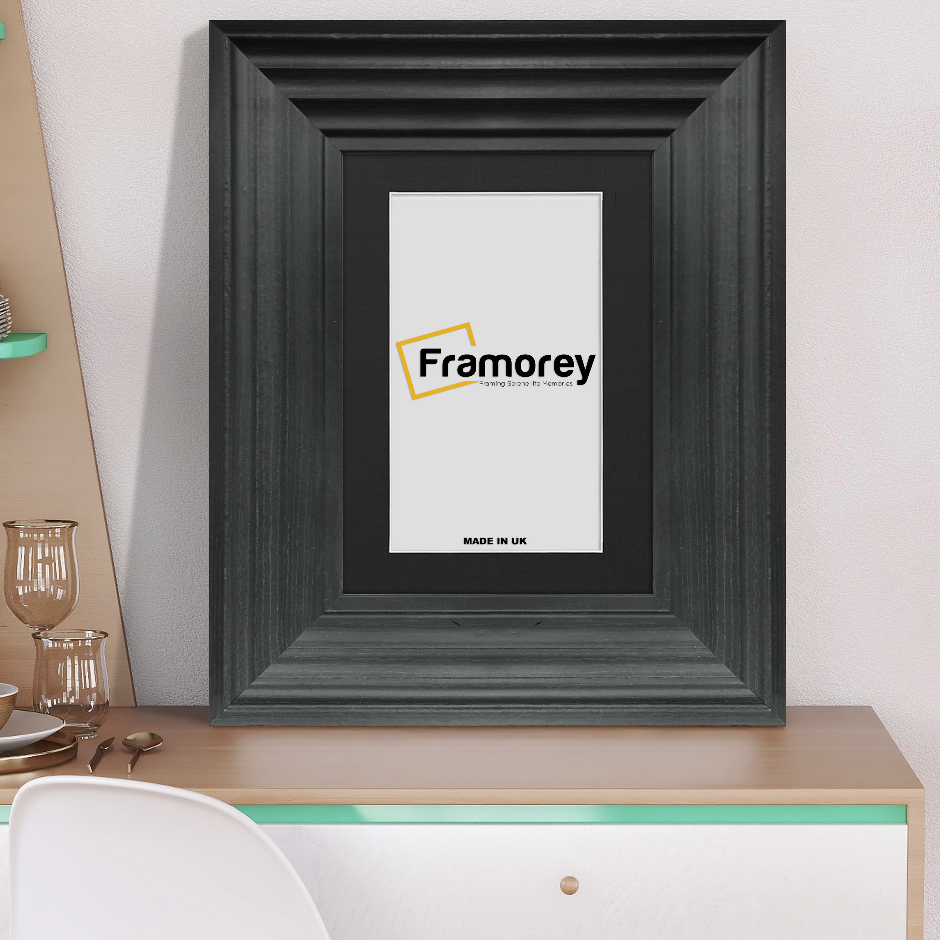 Black wooden picture frame with black mount placed on a table.