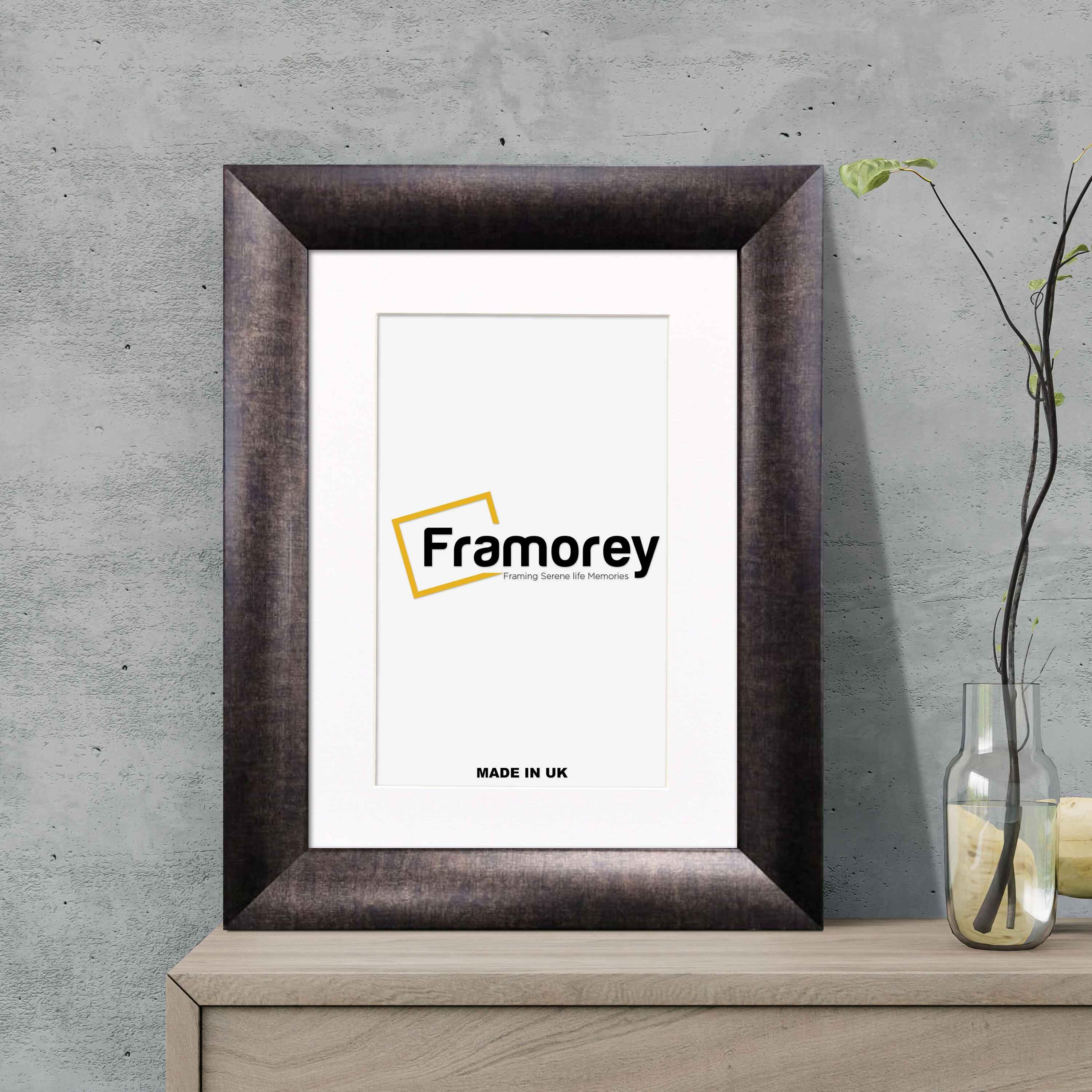 Gold picture frame with white mount shown from front view on wooden surface standing with a wall