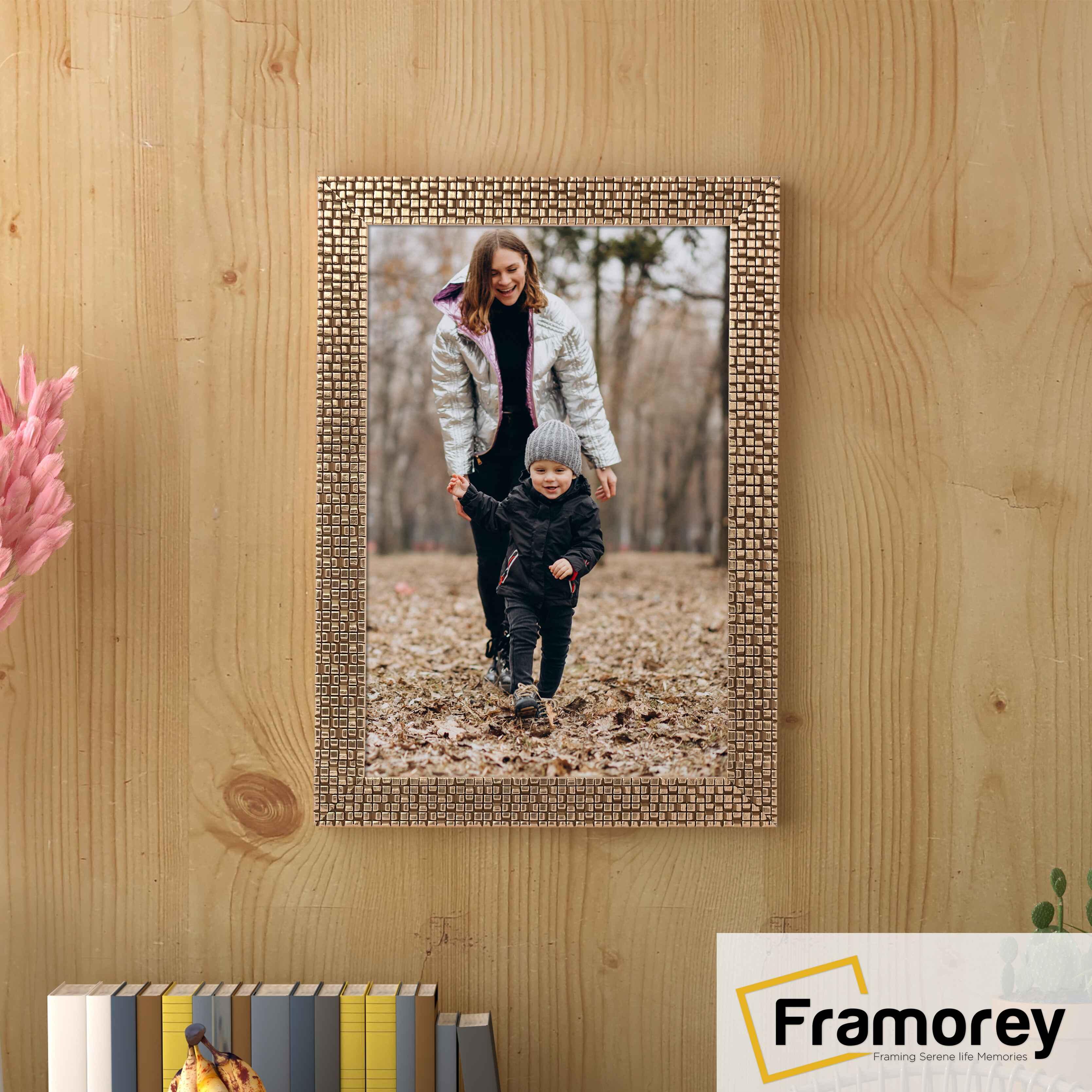 Copper picture frame hanged on a wooden wall.