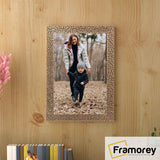 Copper picture frame hanged on a wooden wall.