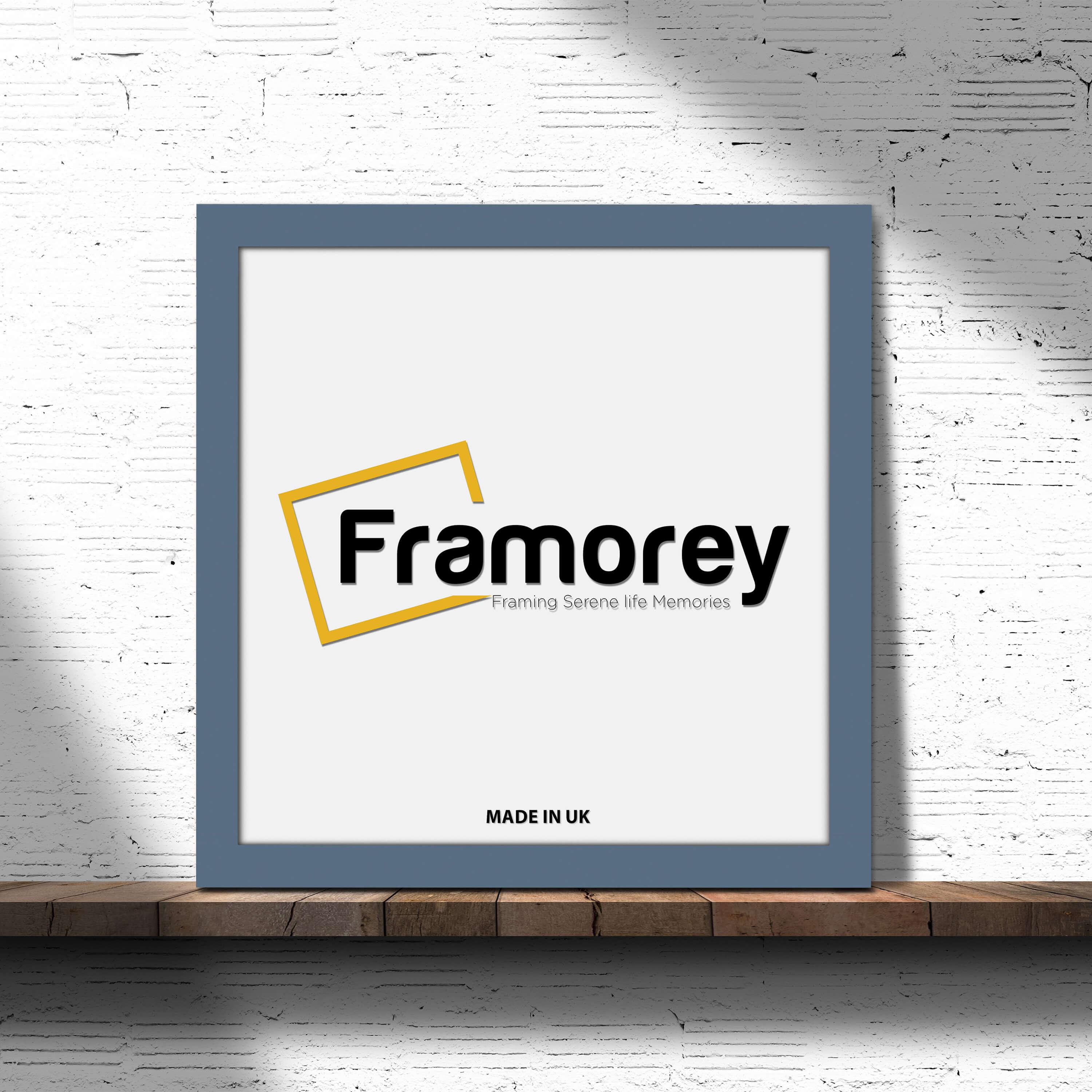 Dark gray picture frame with no mount  placed on a wooden surface.