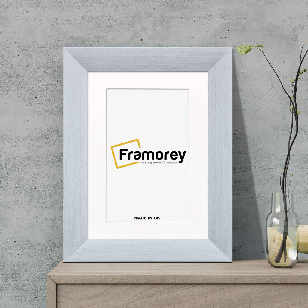 Limed White Picture Frame Poster Frame With White Mount on a wooden table standing with the wall.