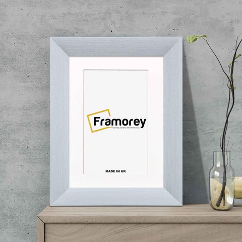 Limed White Picture Frame Poster Frame With White Mount on a wooden table standing with the wall.