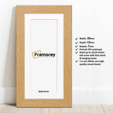 Oak Picture frame with white mount lean with the wall and details.