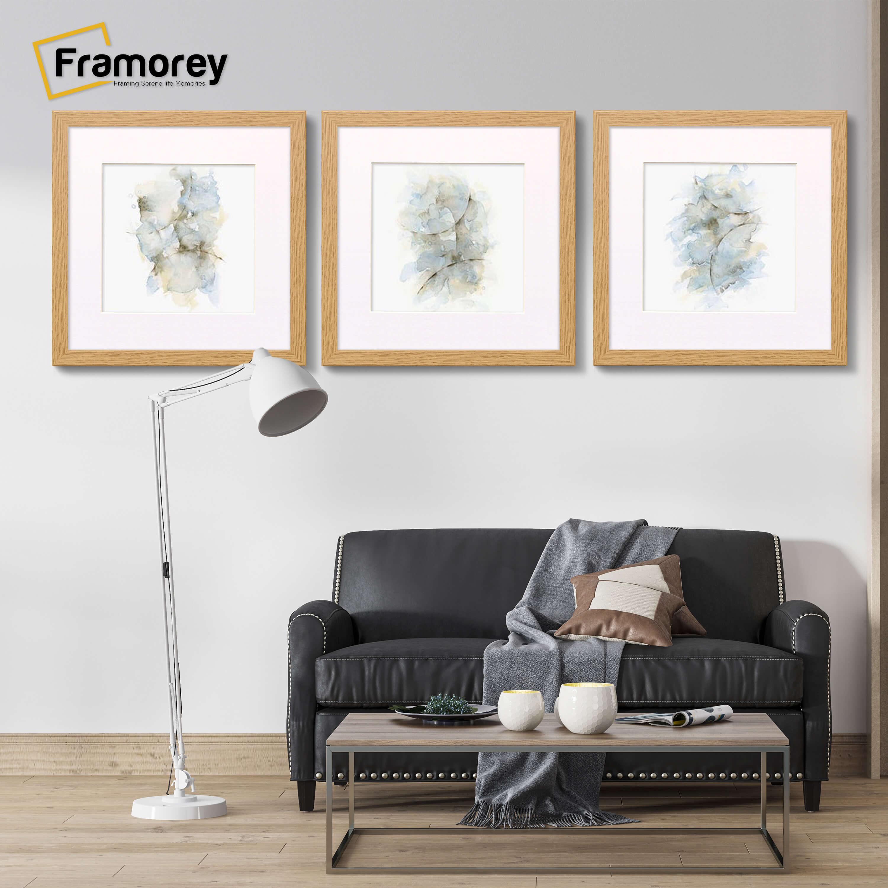 Three Square Size Pine Poster Frame With White Mount hanged on a wall over a couch.
