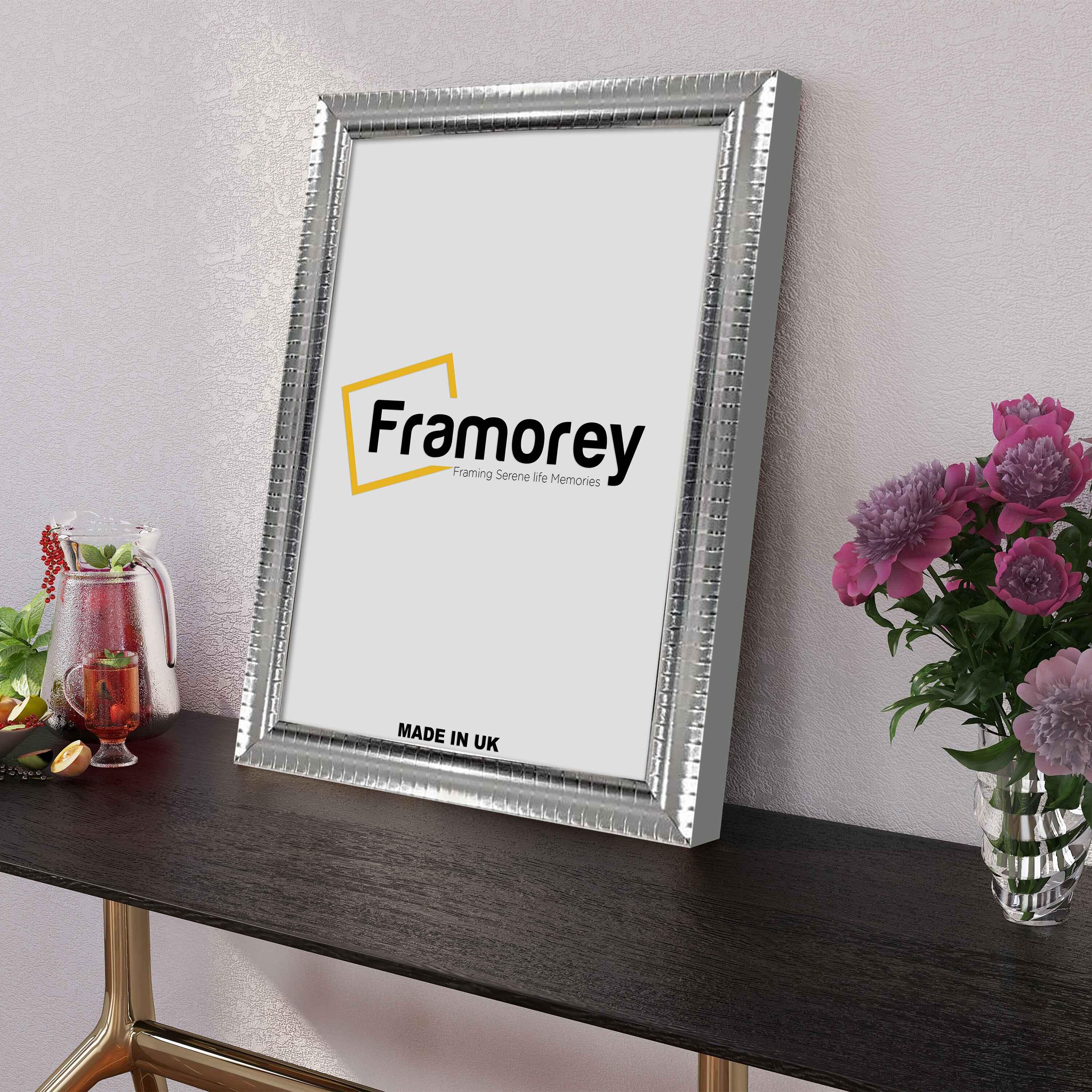 Side view of a Reverse Silver Poster Frame on a table leaning with the white wall.