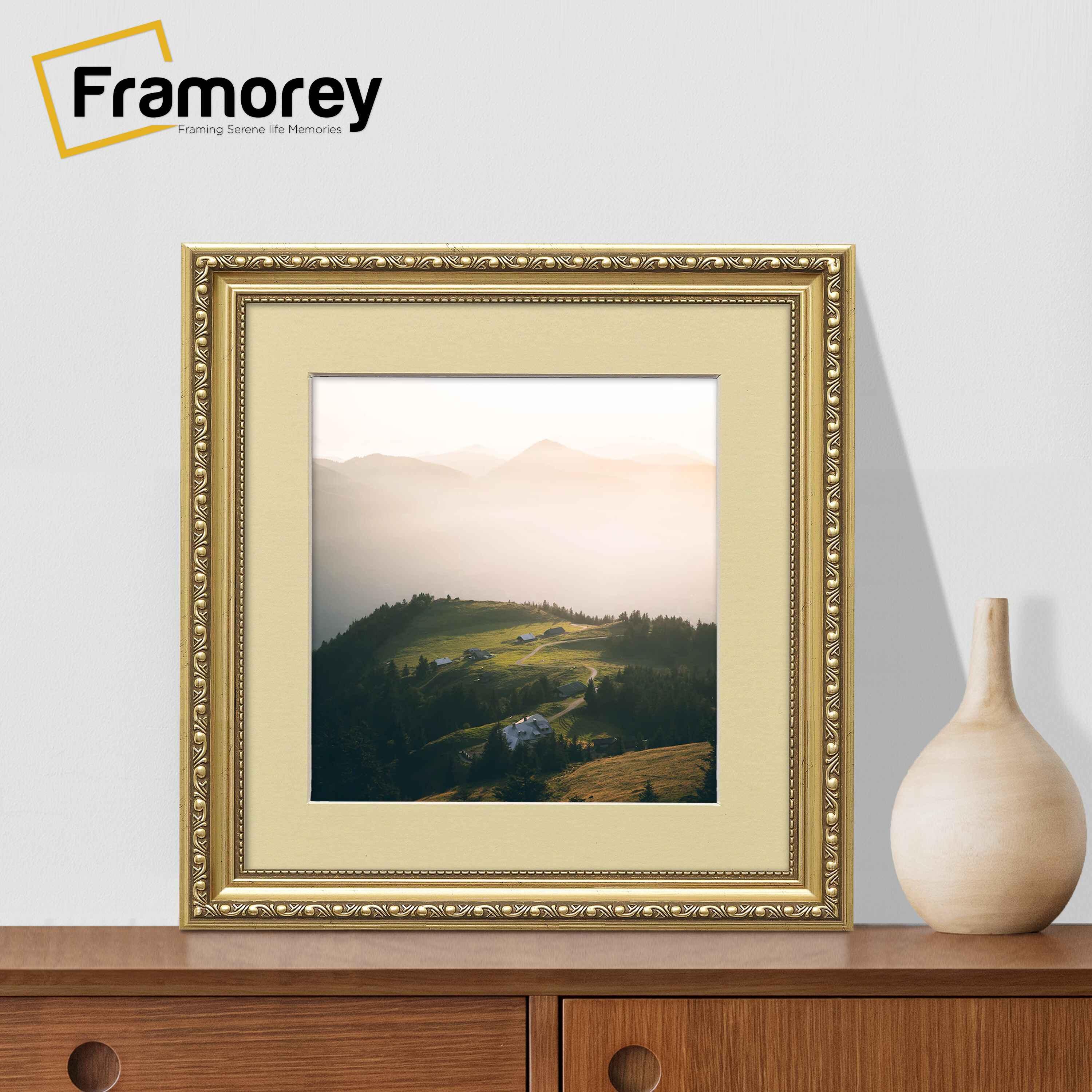 Square gold Ivory Mount shabby photo frame on a table with a vase near it.