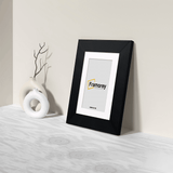 Side view of a Black Picture Frame Poster Frame With White Mount with a framorey logo place in the frame.