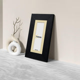 Side view of a Panoramic Black Picture Frames Handmade Wooden Frame is standing with the wall on a wooden surface.