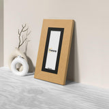 Side view of a Panoramic Oak Photo Print Frame with Black Mount is standing with the wall on a flat wooden surface.