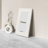 Side view of a Panoramic White Photo Print Frame Handmade Wooden Frame is leaning with the wall on a wooden surface.