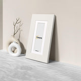Side view of a Panoramic White Photo Print Frame with White Mount is leaning with the wall on a wooden surface.