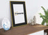 Side view of a Thin Gold Picture Frame With Black Mount with some details with a plate and some bottles placed around it.