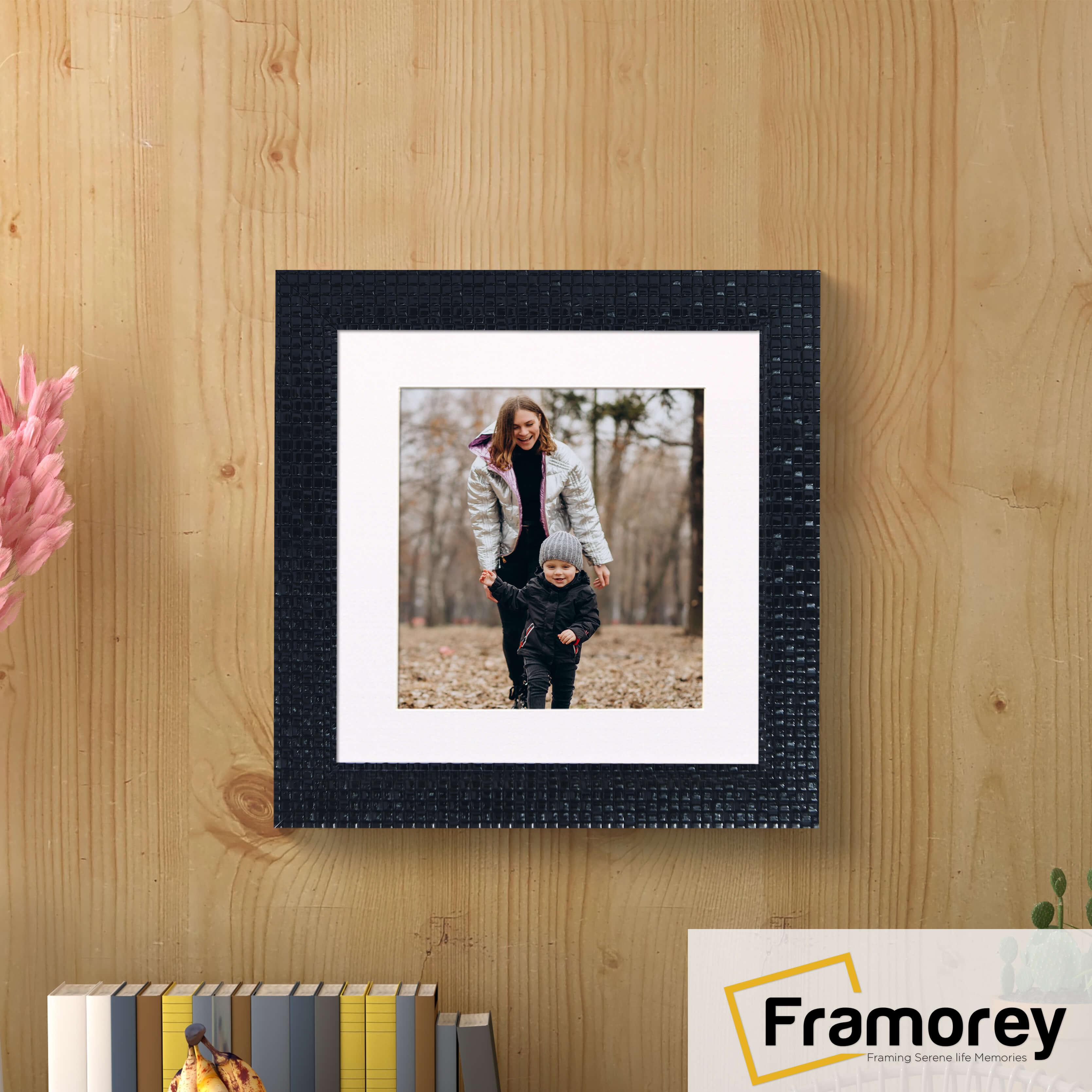 Square Black Photo Frame Rockstar Style With White Mount hanging on a wooden wall.