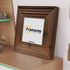 Side view of a Square Size Walnut Wooden Poster Frames Big Step Style placed on a drawer leaning with  the wall.