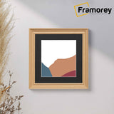 Swept Style Square Oak Photo Print Frame With Black Mount hanging on a wall.