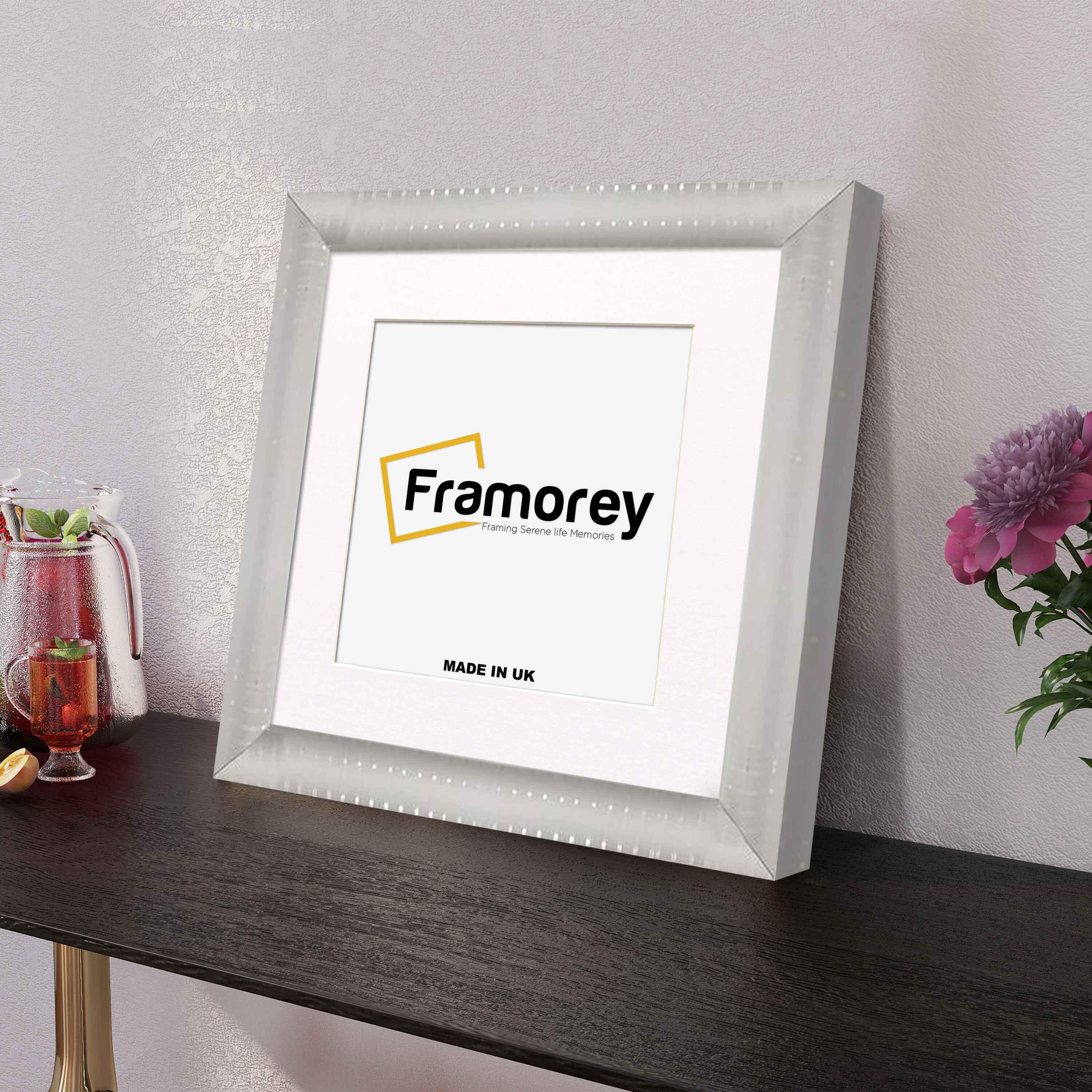 Side View Square silver Reverse Style poster frame with white mount placed on a table.