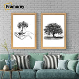 Two antique style oak picture frames displaying black and white artwork hanging above a couch against a brick wall