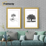 Two antique style gold picture frames with white mounts displaying black and white artwork hanging above a couch against a brick wall