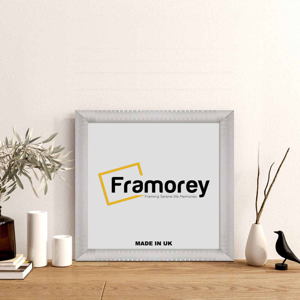 White Square Reverse Style Poster Frame on a floor with some decorative items.