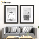 Two Black Picture Frames With White Mount hanging on a wall just over the Couch