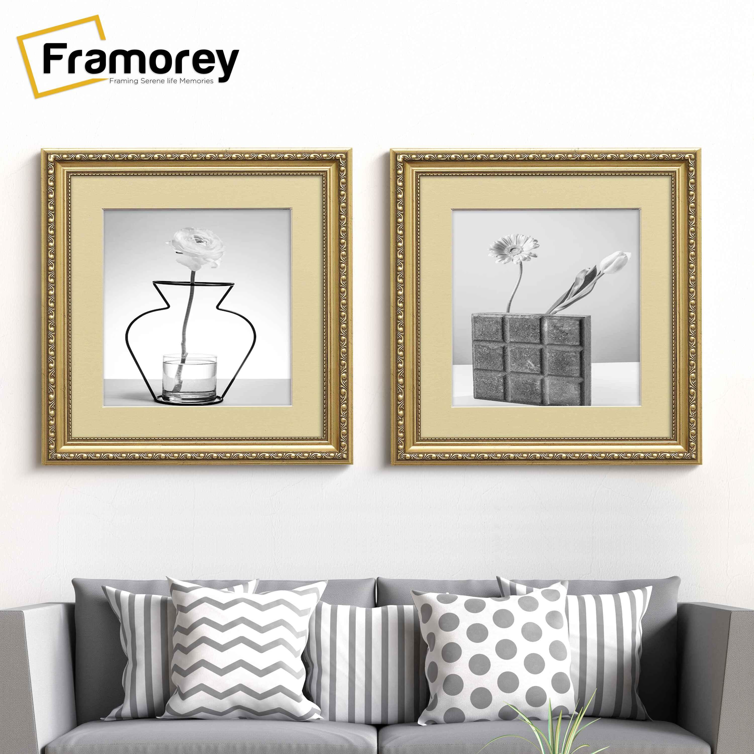Two Square gold Ivory mount shabby photo frames hanged on a wall over the couch.
