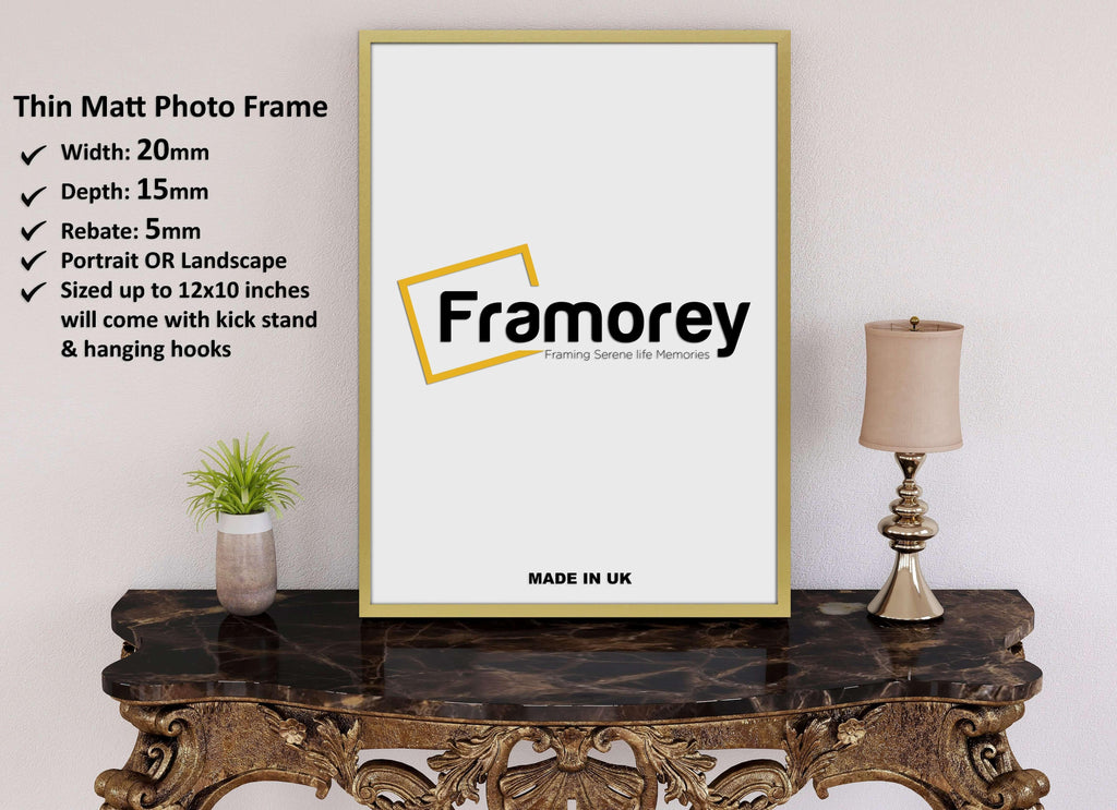 thin flat gold picture frame  placed on a table.